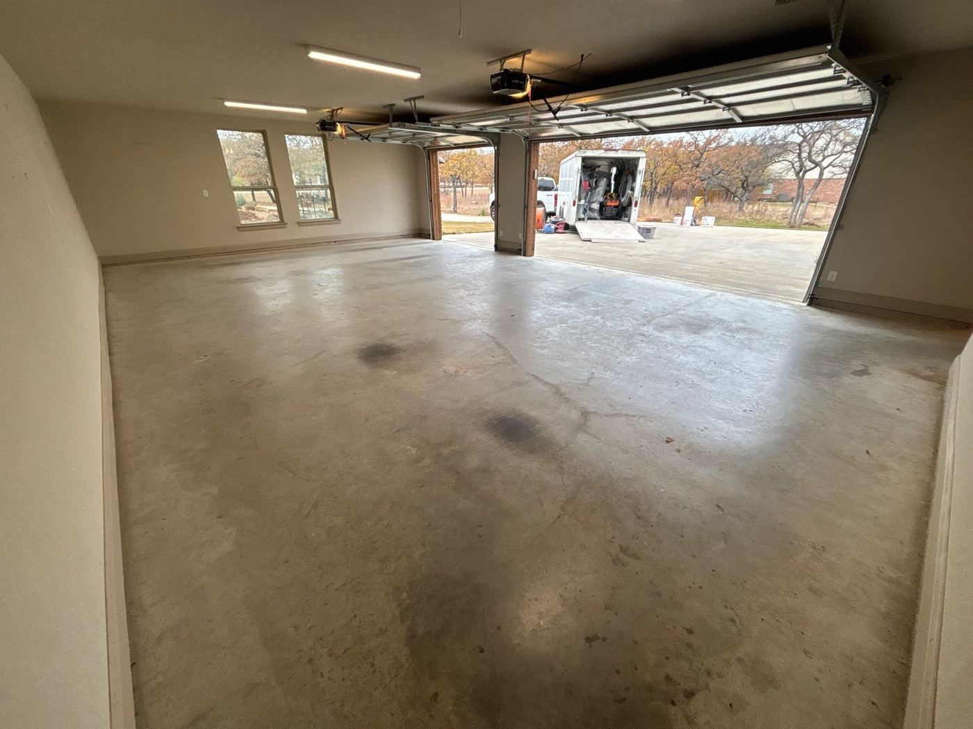 Before: bare concrete garage floor with oil stains and wear — ready for Penntek polyurea coating