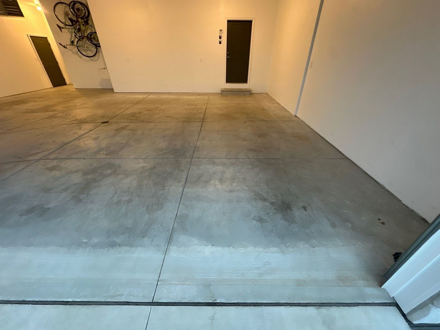 Before: bare concrete large garage floor with staining
